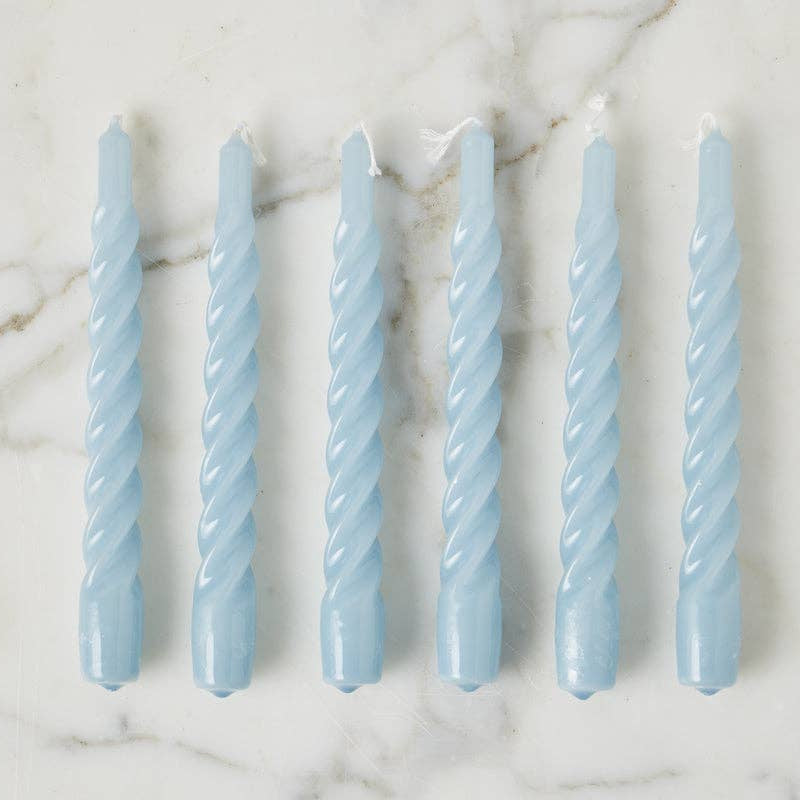 Set of six light blue twisted candles on a marble surface