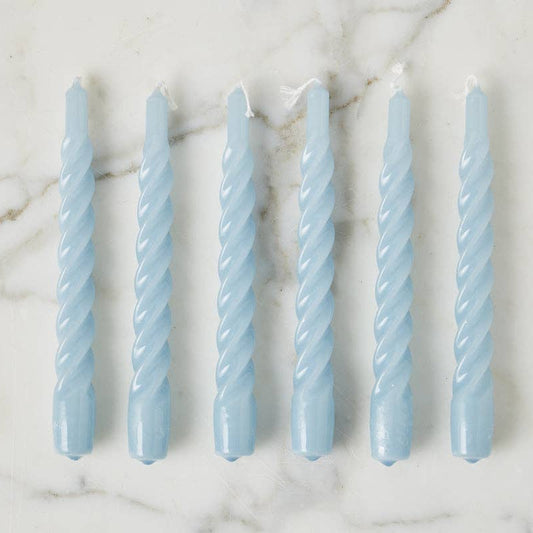 Set of six light blue twisted candles on a marble surface
