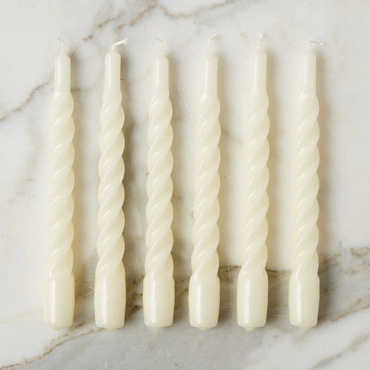 Set of six twisted candles on a marble surface